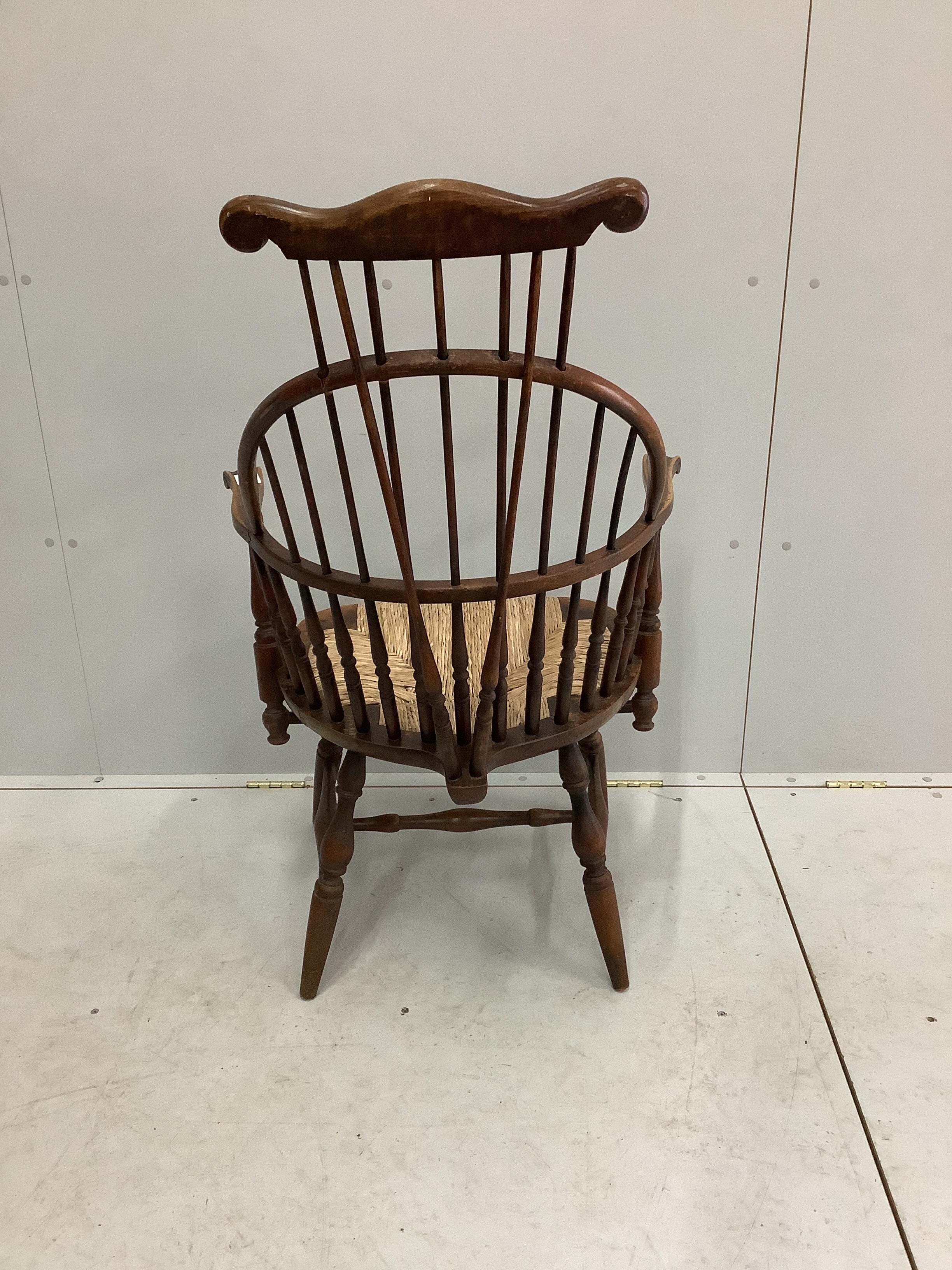 A reproduction American style beech rush seat Windsor comb back armchair, width 64cm, depth 50cm, height 114cm